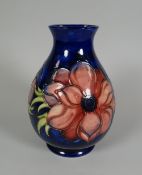 A MOORCROFT BLUE GROUND FLORAL BALUSTER VASE with narrow neck, 18cms high