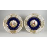 A PAIR OF MEISSEN RIBBON PLATES centred with a hand decorated Watteau-style vignette of courtiers in