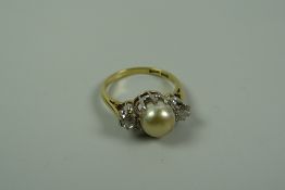 AN 18k YELLOW GOLD RING SET with a pair of round cut diamonds & a raised centre pearl, 4.8gms