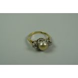 AN 18k YELLOW GOLD RING SET with a pair of round cut diamonds & a raised centre pearl, 4.8gms