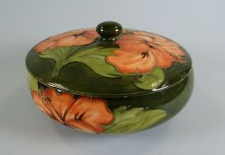 A MOORCROFT GREEN GROUND TUBE-LINED FLORAL DISH & COVER with raised knop, 17cms diam