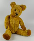 AN ENGLISH GOLDEN PLUSH early twentieth century teddy bear with moving limbs & head, glass eyes,