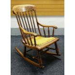 AN UNUSUAL NINETEENTH CENTURY ROCKING CHAIR having tapering turned bobbin back, sides &