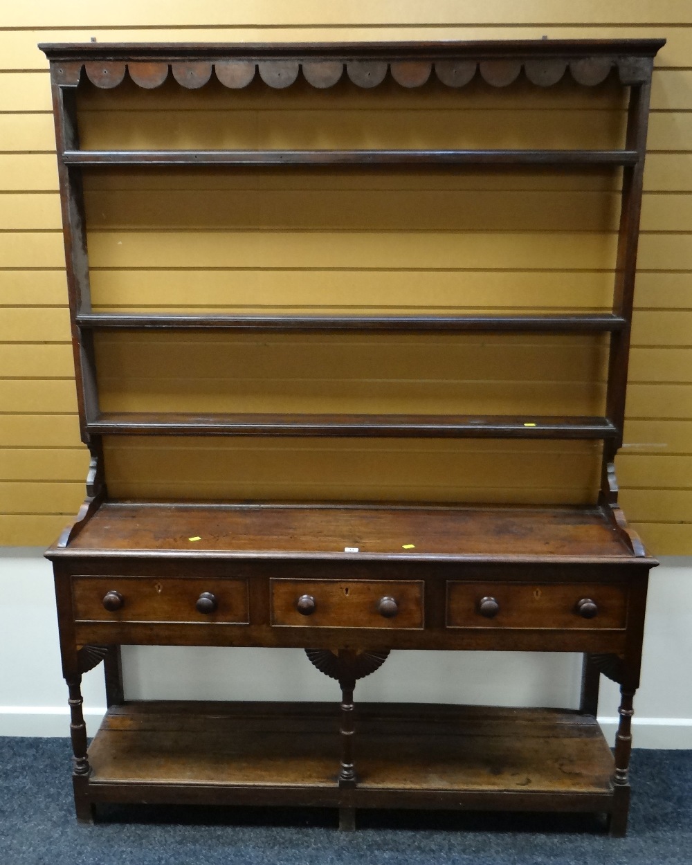 A NINETEENTH CENTURY OAK SWANSEA WELSH DRESSER having a three-drawer base raised over a platform &