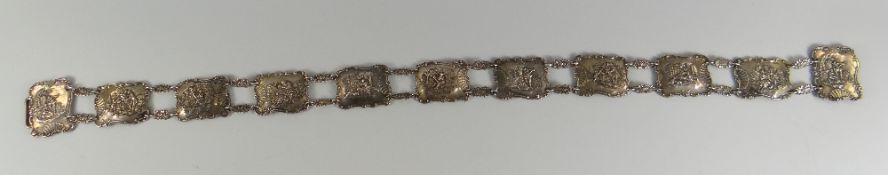 A GOOD ELEVEN PANEL SILVER BELT each panel with relief depictions of villages & musicians etc,