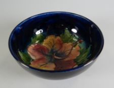 A MOORCROFT DEEP BLUE GROUND FLORAL FOOTED BOWL, 13cms diam