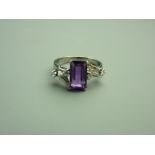 A FOURTEEN CARAT WHITE GOLD AMETHYST & DIAMOND DRESS RING, the emerald cut moderate purple