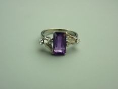 A FOURTEEN CARAT WHITE GOLD AMETHYST & DIAMOND DRESS RING, the emerald cut moderate purple