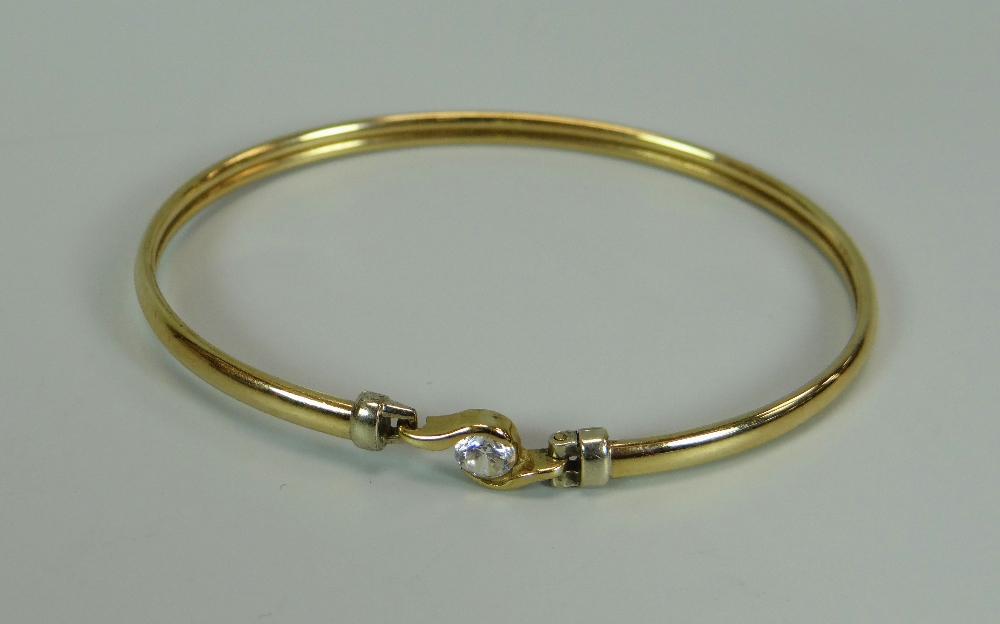 A 9K YELLOW GOLD BANGLE WITH SOLITAIRE CZ