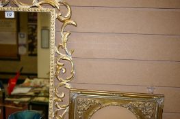 Elaborate metal framed wall mirror and an oval gilt picture frame
