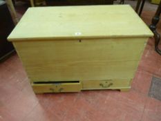 AN ANTIQUE STRIPPED PINE MULE CHEST with iron carry handles and twin lower drawers having swan