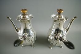 A PAIR OF ATTRACTIVE SILVER CHOCOLATE POTS of globular narrowing form and with raised scrolled
