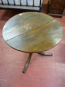AN ANTIQUE OAK TILT TOP TRIPOD TABLE, the 73 cms diameter top over a turned urn shaped column and