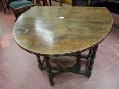 A SMALL ANTIQUE OAK GATE LEG DINING TABLE, oval topped when open on turned and block supports and
