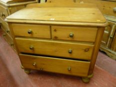 A VICTORIAN STRIPPED PINE RAIL BACK CHEST of two short over two long drawers having brass knobs,