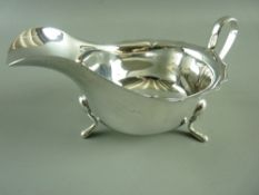 A SILVER SAUCE BOAT, Sheffield 1931, 3.3 troy ozs with wavy rim and 'C' shaped handle, on three