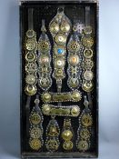 SHIRE/HEAVY HORSE BRASSWARE - a 4ft display board with eleven antique harness martingales containing