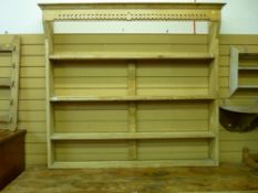 A VINTAGE STRIPPED PINE OPEN DELFT RACK with pierced front detail and four shelves, 137 cms high,