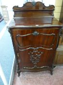 A LATE VICTORIAN MAHOGANY MUSIC CABINET by Maple & Co, the shaped top and back rail with carved