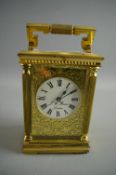 A BRASS CASED CARRIAGE CLOCK retailed by J W Benson, London, the four glass case with reeded
