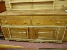 AN ANTIQUE PINE KITCHEN DRESSER BASE having two central drawers with turned wooden knobs and lower