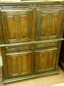 A EUROPEAN CARVED OAK CUPBOARD with two upper and two lower doors with a pair of central drawers