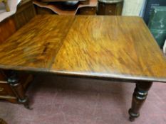 Victorian mahogany dining table on substantial turned supports and brass castors