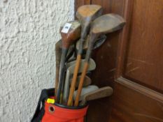 Quantity of vintage golf clubs in a red bag