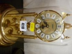 Gilt anniversary clock under a plastic dome