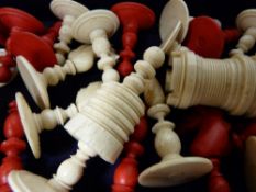 Vintage stained and carved bone chess pieces in a wooden box