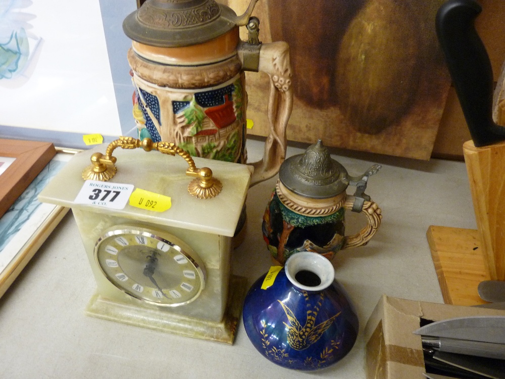 Onyx mantel clock, two German pottery steins and a Crown Devon lustre vase