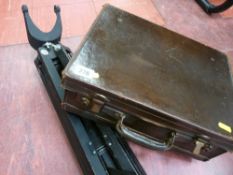 Vintage small leather suitcase and a surveyor's tripod stand