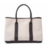 Hermès, Handtasche "Garden Party" Beigefarbenes Canvas und dunkelbraunes Leder. Zwei Traggriffe.