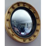 A Pair of Regency Circular Gilt Framed Convex Mirrors, the plates each within an ebonised reeded