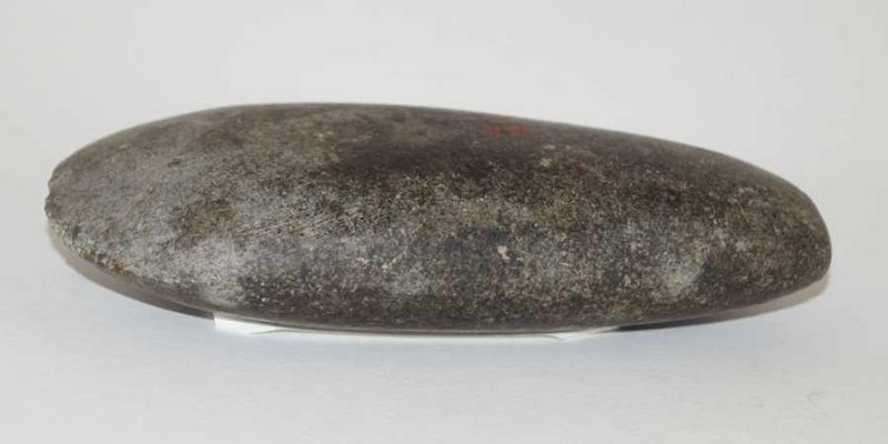 Steinbeil, Brasilien L. 15,5 cm, H. 3,5 cm. Grau-braunes, oval-zugespitztes Beil. Matt poliert. Rote