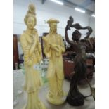 Two plaster figurines depicting oriental man and woman and spelter figurine