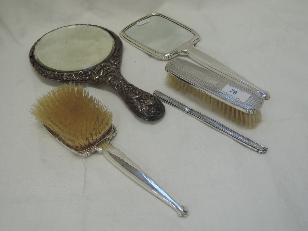 A silver three piece dressing table set having engine turned decoration and plain cartouche,
