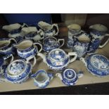 A shelf of blue and white tea pots and jugs including Burleigh and Wedgwood