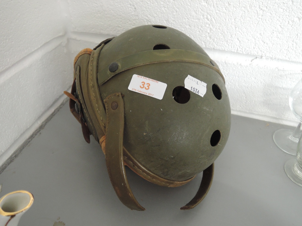 A vintage crash hat with leather ear protectors by Rawlings