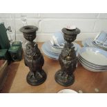 A pair of bronze effect candlesticks in the form of owls