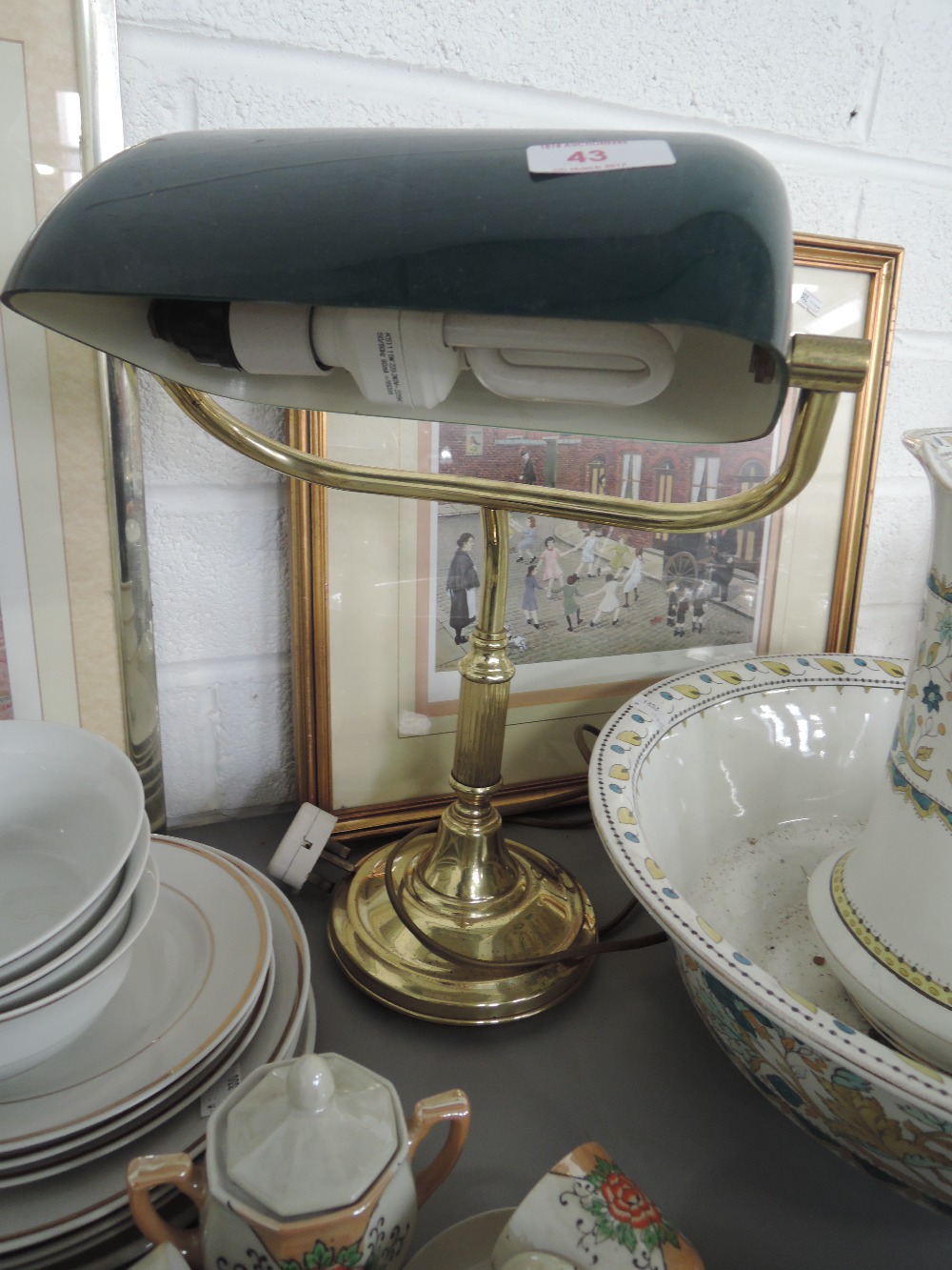 A brass desk lamp with green shade