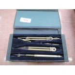 A vintage set of brass compasses and dividers in lined box