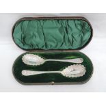 A cased pair of Victorian silver berry spoons having extensive bright cut and engraved decoration to