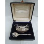 A cased Arts and Crafts style silver and wood mazer and spoon having plannished and wire decoration,