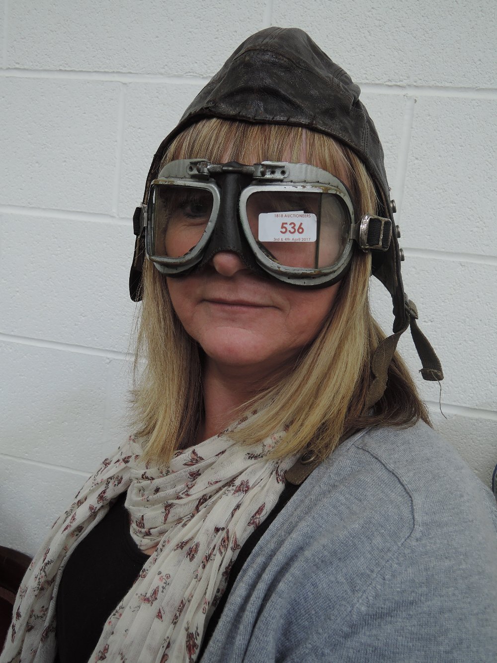 A pair of vintage flying goggles and a leather flying helmet