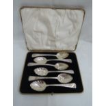 A cased set of six (5 & 1) Georgian silver berry spoons having bright cut floral engraving to