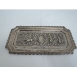 A small Indian white metal tray of canted rectangular form having repousse scenic decoration