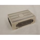 A silver match box cover having engraved stripped decoration and plain cartouche, Chester 1928,