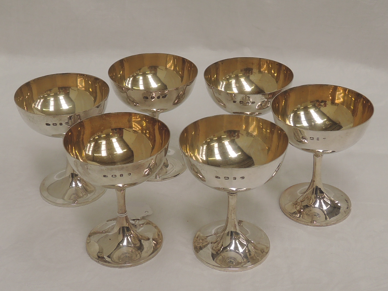 A set of six Victorian silver champagne coupes of plain form having gilt bowls, Birmingham 1898,