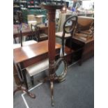 An early 20th century mahogany torchere stand having circular platform top, reeded column and triple
